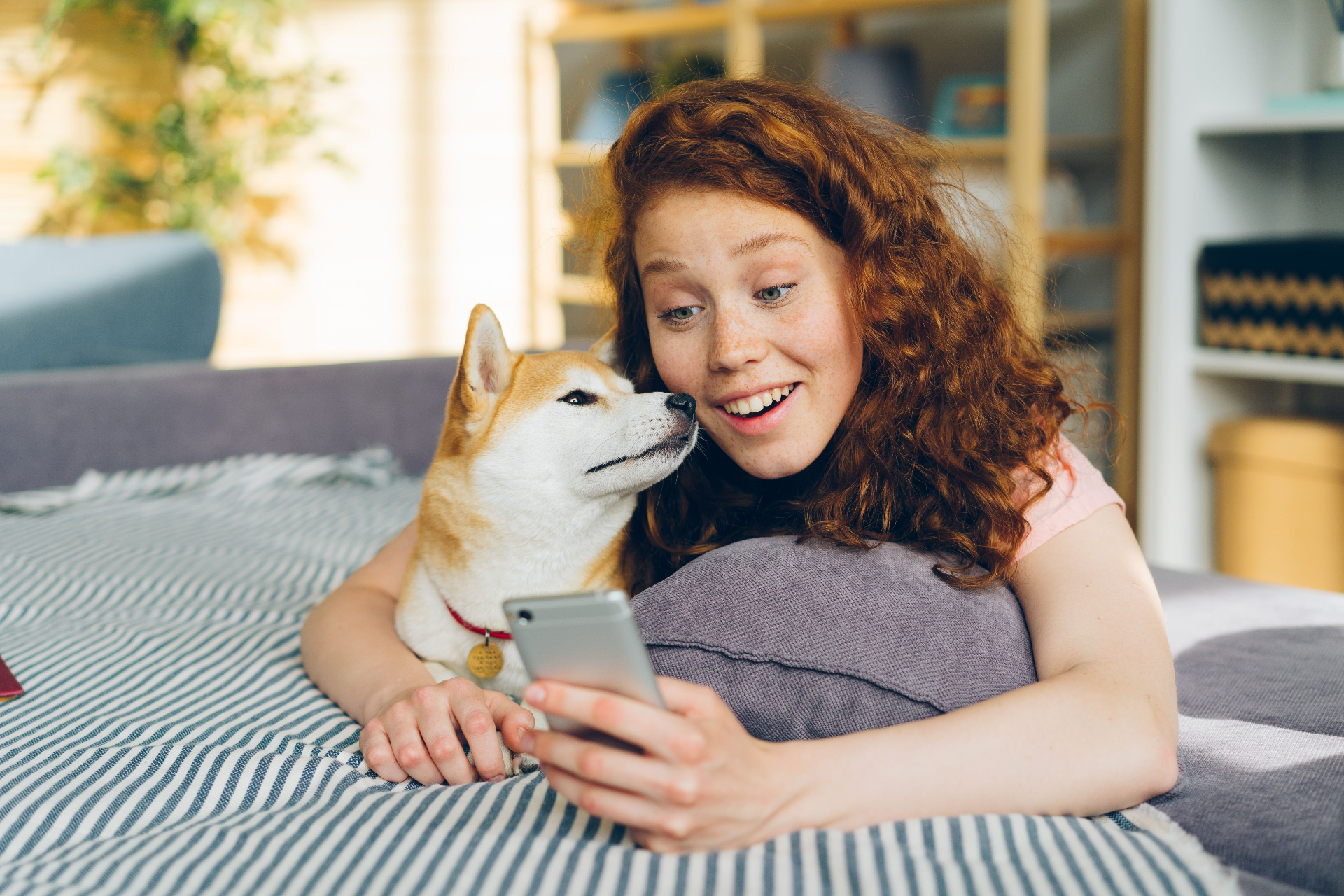 Tutora pelirroja con su Shiba consultando el móvil — Mascotas en Red